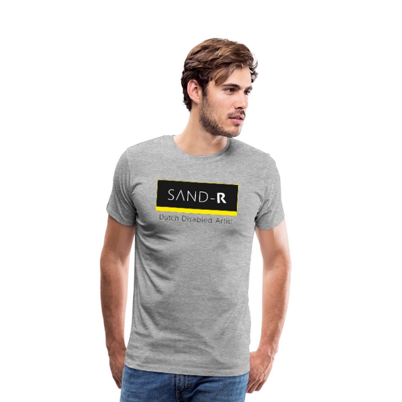 Blanke licht bebaarde man met lichtbruin haar draagt een grijs t-shirt met de tekst: SAND-R, Dutch Disabled Artist.